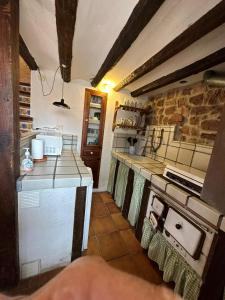 uma cozinha com um fogão e uma bancada em Casa Castillo em Vilafamés