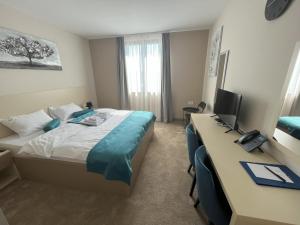 Habitación de hotel con cama y escritorio con ordenador en Garni Hotel IMPERIUM Subotica en Subotica