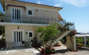 a house with a staircase in front of it at Raymondos Apartments in Lassi