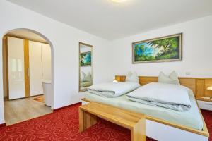 - une chambre avec 2 lits et un tapis rouge dans l'établissement Landhaus Lengg, à Reit im Winkl