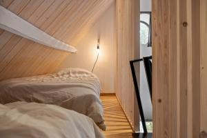 a bedroom with two beds and a light on the wall at Hoeve-C in Ieper +20 photos