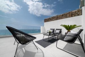 Un balcón con sillas y vistas al océano. en Preciosa casa frente al mar, en Montgat