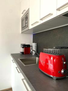 una tostadora roja está sentada en un mostrador de cocina en Life Studio & City Bike, en Bolzano