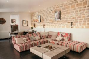 a living room with two couches and a brick wall at Le Grand Arches in Charleville-Mézières