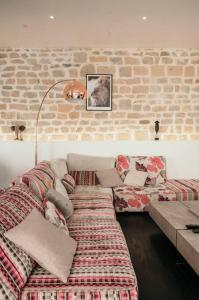 a living room with a couch and a brick wall at Le Grand Arches in Charleville-Mézières