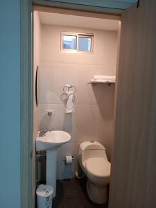 a small bathroom with a toilet and a sink at Hotel Prado 53 in Barranquilla