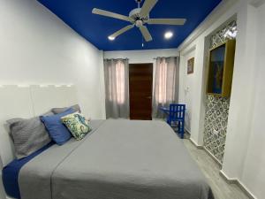 a bedroom with a large bed with a ceiling fan at Casa María in Isla Mujeres