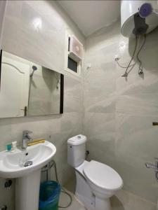a bathroom with a white toilet and a sink at نزل المنتجع السياحية in Al Namas