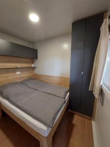 - une petite chambre avec un lit et une armoire dans l'établissement Casa Malu - mobile house by the Kolpa river, à Metlika