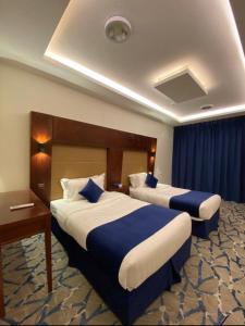 a hotel room with two beds and a desk at نزل المنتجع السياحية in Al Namas
