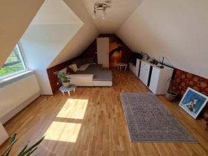 an attic living room with a couch and a kitchen at Cozy Country Side House in Kütke