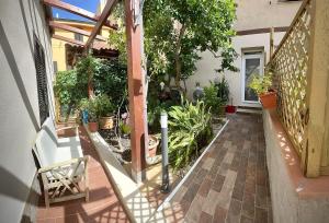 een huis met een veranda met planten en een stoel bij Baia delle foche in Fertilia