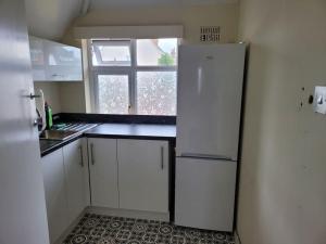 a kitchen with a white refrigerator and a window at Rest & Relax Apartment in Tilehurst