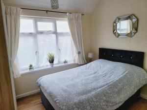 a bedroom with a large bed and a window at Rest & Relax Apartment in Tilehurst
