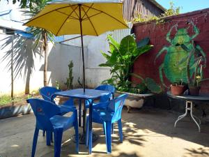 Casaclub Hostel في فالبارايسو: طاولة زرقاء مع كراسي زرقاء ومظلة