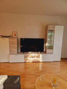 ein Wohnzimmer mit einem großen TV und einem Tisch in der Unterkunft Wohlfühloase in Sankt Wendel