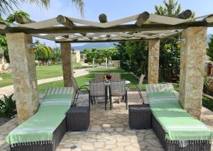 a patio with a pergola and a table and chairs at Villa Skala Atalantis in Skála