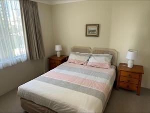 a bedroom with a bed with two night stands and two lamps at Beachpoint, Unit 101, 28 North Street in Forster