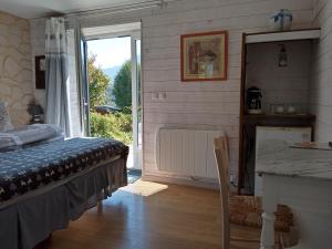 a bedroom with a bed and a door to a window at CHALET HARMONIE in Auris