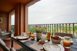 een houten tafel met eten en drinken op een balkon bij Paradise Rentals Denia VilaMar 2 in Denia