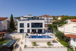 duży biały dom z basenem i domów w obiekcie Villa Julian with a heated pool w Trogirze
