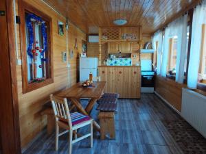 a kitchen with a table and chairs in a cabin at Cabana La Bunici in Piatra Neamţ