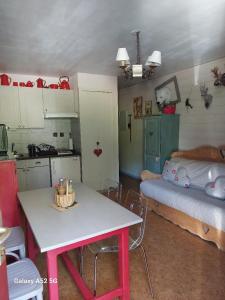 een keuken met een tafel en een bed in een kamer bij Appartement Cosy au cœur de Saint Lary in Saint-Lary-Soulan