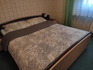 a bed with a brown comforter in a bedroom at Apartma Čampa in Kočevje