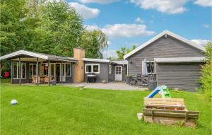 a backyard with a house and a lawn at Amazing Home In Jgerspris With Wifi And 2 Bedrooms in Jægerspris