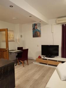 een woonkamer met een flatscreen-tv en een tafel bij Studio D&D in Vrh