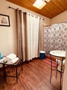um quarto com uma mesa e cadeiras e uma janela em El Extranjero Hostal em Antigua Guatemala