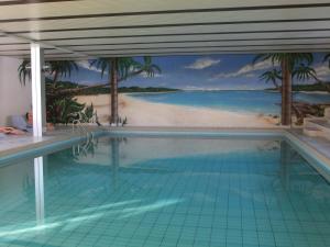 a swimming pool with a mural of a beach at Appartement avec vue imprenable in La Tzoumaz