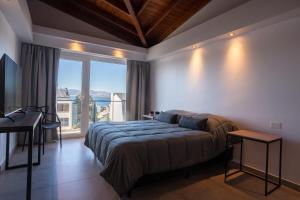 1 dormitorio con cama y ventana grande en Portales de la Patagonia Apartments en San Carlos de Bariloche