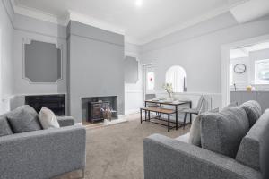 a living room with two couches and a dining room at The Yorkshire Hosts - Central Castleford 4 Bed House - Free Parking in Castleford