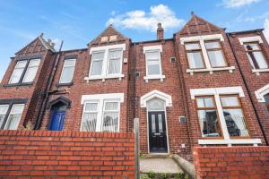 a brick house with white windows and a red brick wall at The Yorkshire Hosts - Central Castleford 4 Bed House - Free Parking in Castleford
