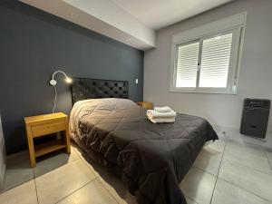 a bedroom with a bed and a lamp and a window at Departamento por día para 4 personas con cochera cubierta en Bahía Blanca in Bahía Blanca +10 photos