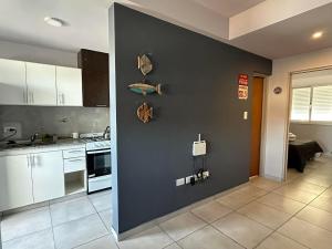 a kitchen with white cabinets and a black wall at Departamento por día para 4 personas con cochera cubierta en Bahía Blanca in Bahía Blanca