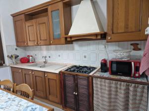 cocina con armarios de madera y horno con fogones en Alcivico26 en Alghero