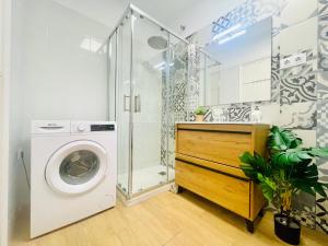 y baño con lavadora y ducha. en Precioso y exclusivo piso en centro de Tarragona, en Tarragona