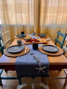 un tavolo in legno con piatti e cibo sopra di Apartamento “La Caleta” a Calella