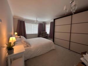 a bedroom with a large white bed and a desk at Rachelle's Place in Kent
