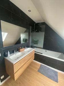 a bathroom with two sinks and a bath tub at Maison Beau in Veurne