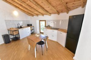 a kitchen with a table and a black refrigerator at Casa Botijo by SIERRA VIVA desing in Linares de la Sierra