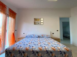 ein Schlafzimmer mit einem Bett mit einer bunten Bettdecke in der Unterkunft Le mimose in Alba Adriatica