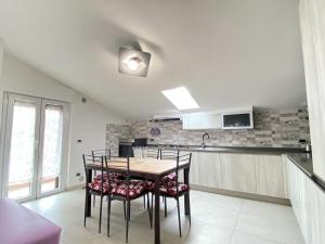 una cucina con un tavolo e sedie in una stanza di Le mimose ad Alba Adriatica