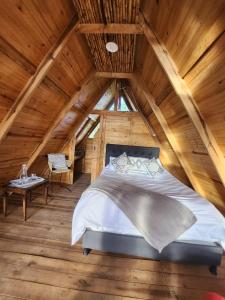 ein Schlafzimmer mit einem Bett im hölzernen Dachgeschoss in der Unterkunft Glamping El Muelle in Villa de Leyva