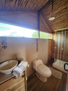 La salle de bains est pourvue de toilettes, d'un lavabo et d'une baignoire. dans l'établissement Glamping El Muelle, à Villa de Leyva