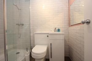 y baño blanco con aseo y ducha. en Central London Apartment Zone 1 en Londres