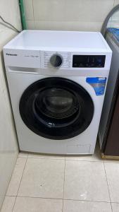 a white washing machine sitting on the floor at Dinar apartments in Abu Dhabi