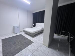 1 dormitorio con cama y ventana grande en Dinar apartments, en Abu Dabi
